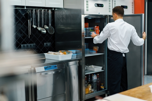 Chef pegando insumos em geladeira comercial