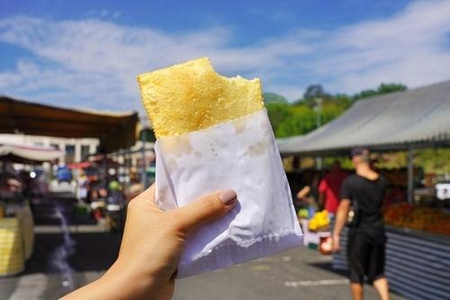 Recheios de pastel - mão segurando pastel em lugar público