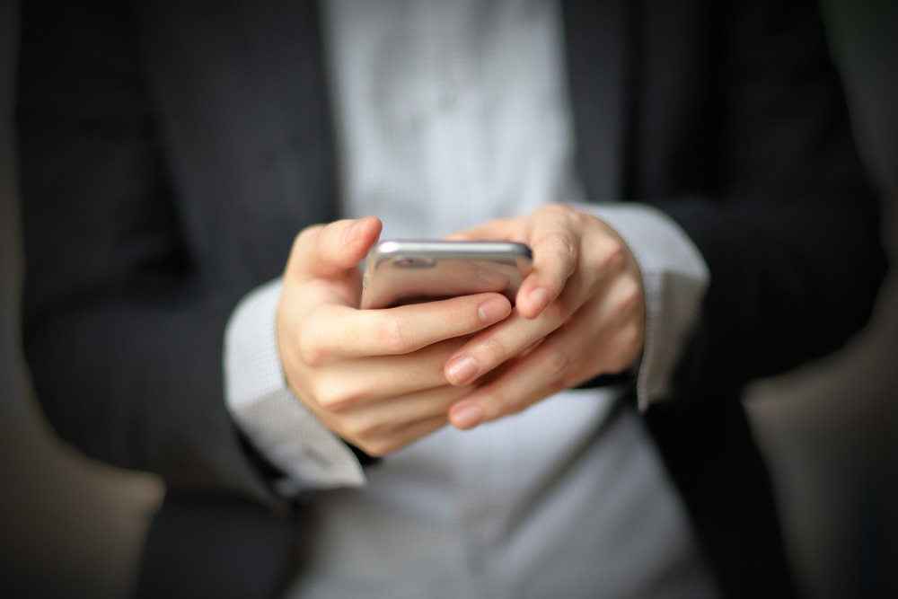 Empreendedor olhando concentrado para Registrato no celular