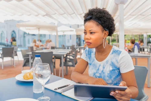 Solo dining - mulher trabalhando enquanto come sozinha em restaurante